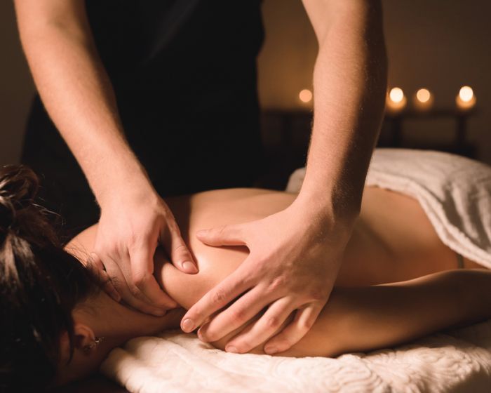 Close up Male manual worker doing spa massage to a young girl in a dark room