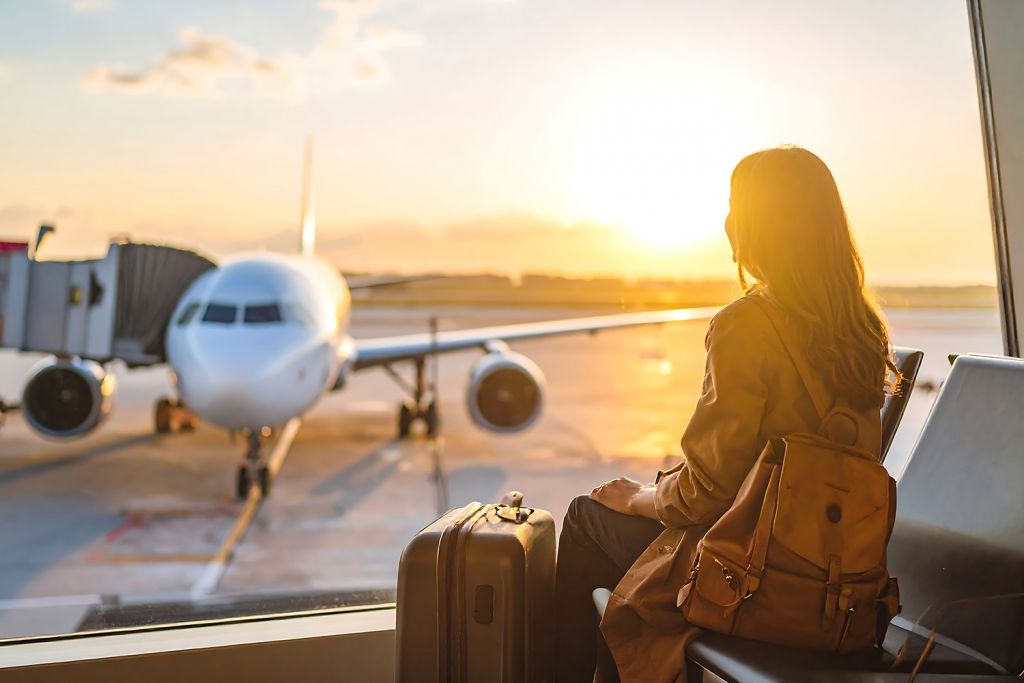 woman with bags at Cleveland airport considering layover wellness experiences