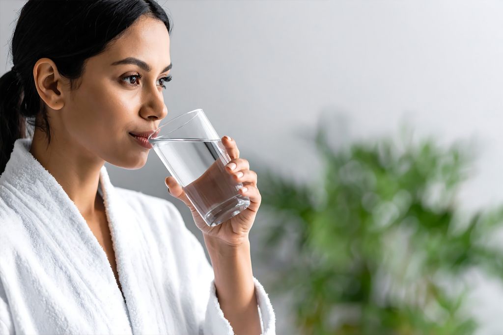 woman hydrating after sauna