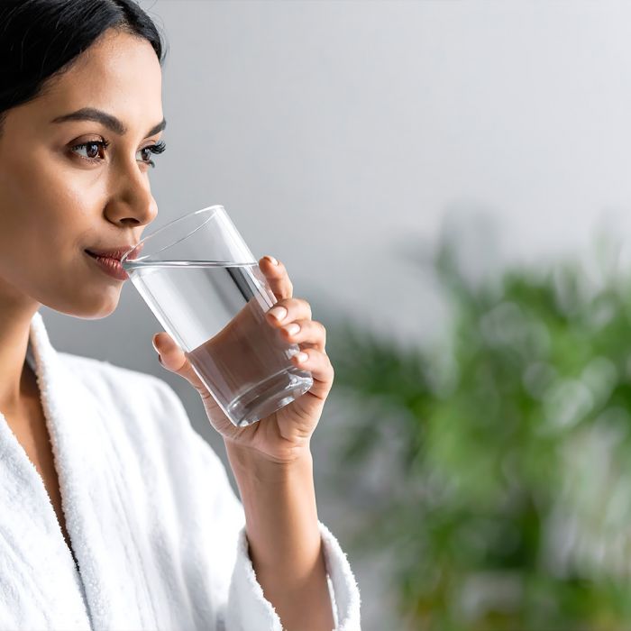 woman hydrating after sauna